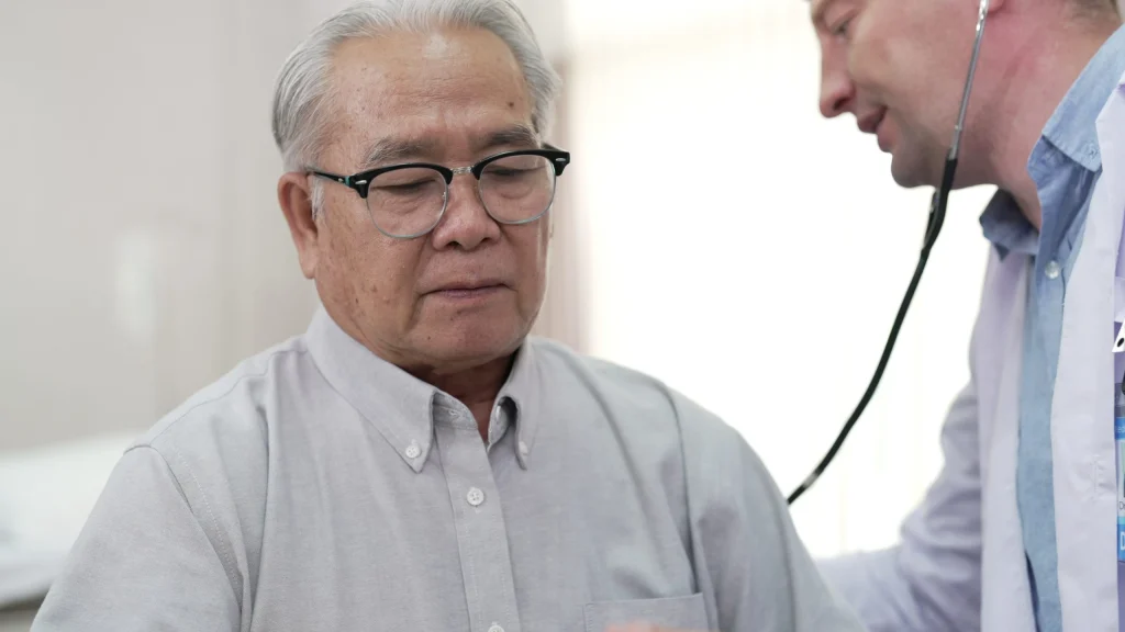 Profissional de saúde realizando atendimento clínico em paciente adulto em ambiente médico